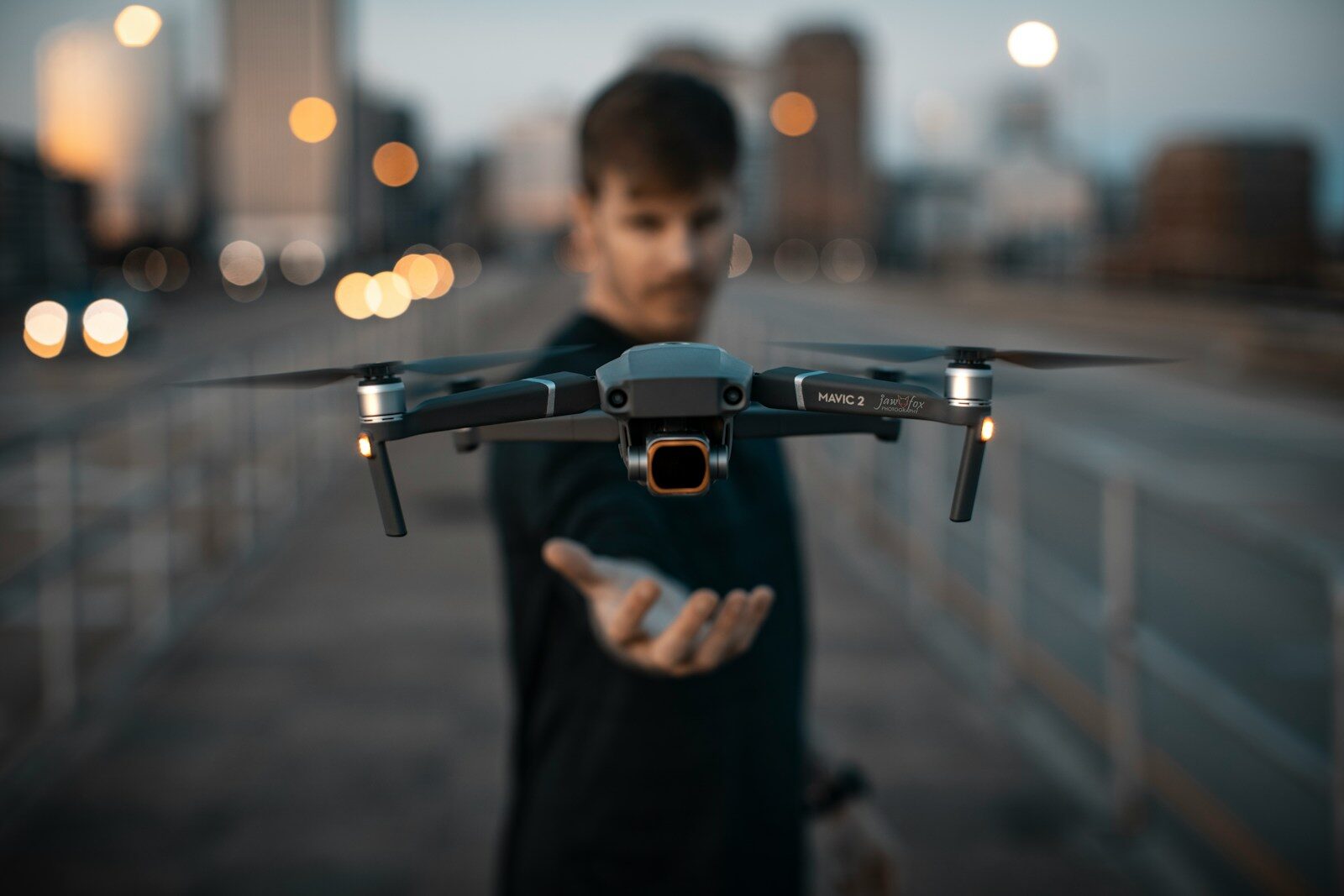 man in black shirt holding black and gray drone